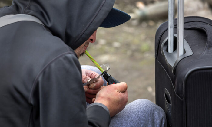 A homeless man, 24,  smokes fentanyl in Seattle, Wash., on March 12, 2022. Widespread drug addiction is endemic in Seattle's large homeless community, which the city is currently trying to move out from shared public spaces. (John Moore/Getty Images)