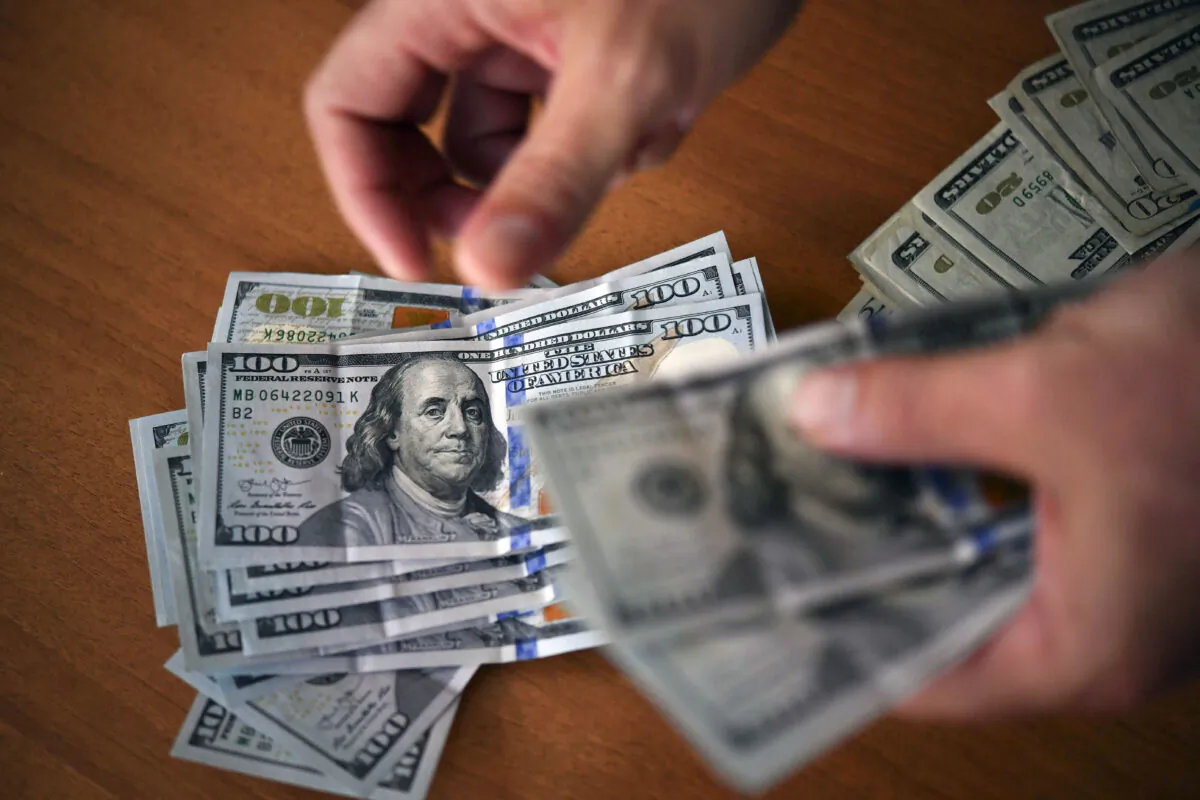 File photo of a man counting US dollars. (Yuri Cortez/AFP via Getty Images)