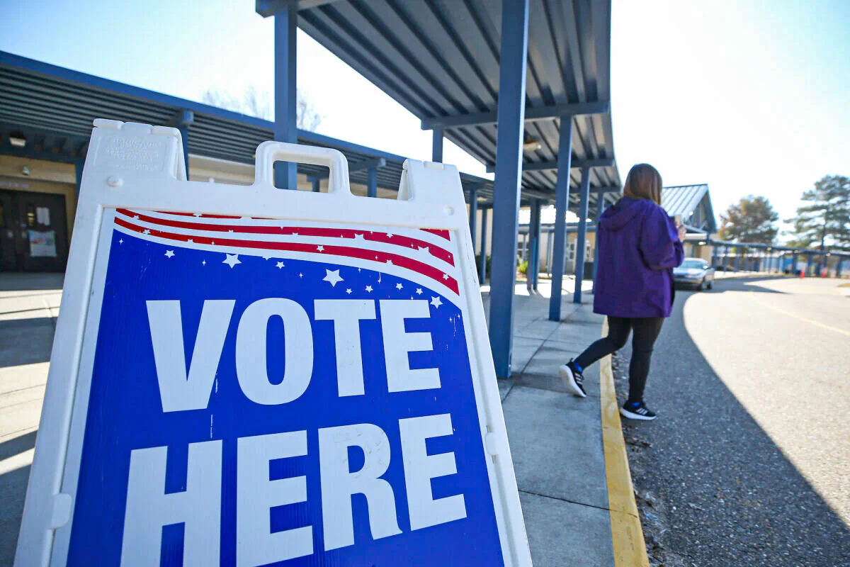 A person walks past a sign during a runoff election for Louisiana governor at a polling station at Quitman High School in Quitman, La., on Nov. 16, 2019. (Matt Sullivan/Getty Images)