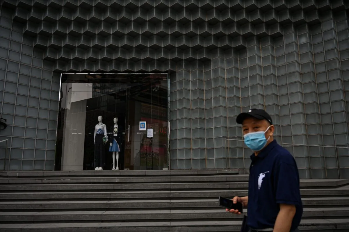 A man walks past a closed shop during a COVID-19 lockdown in the Jing'an district of Shanghai on May 30, 2022. (Hector Retamal/AFP via Getty Images)