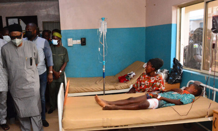 State officials walk past injured victims on hospital beds being treated for wounds following an attack by gunmen at St. Francis Catholic Church in Owo town, southwest Nigeria on June 5, 2022, according to the government and police.  (AFP via Getty Images)