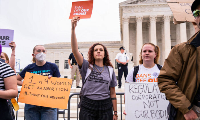 Activists protest in response to the leaked Supreme Court draft decision to overturn Roe v. Wade in front of the U.S. Supreme Court on May 3, 2022. (Louis Chen/The Epoch Times)