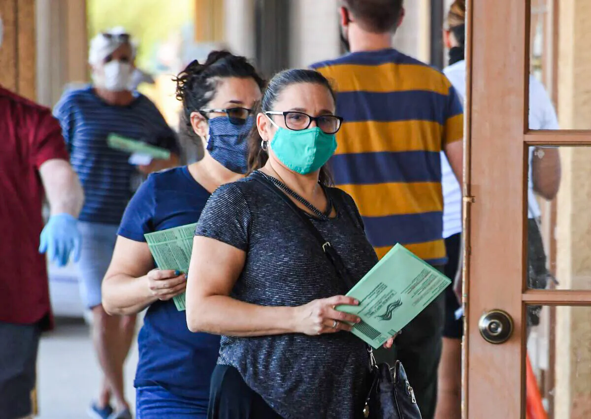 People wait in line to drop off mail-in ballots in a file photo. (Robyn Beck/AFP via Getty Images)