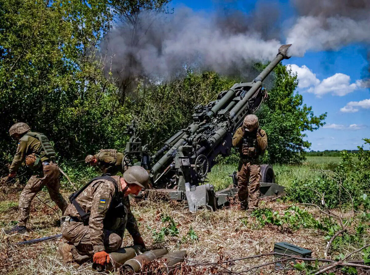 Ukrainian service members fire a shell from a M777 Howitzer near a frontline in Donetsk Region, on June 6, 2022. (Stringer/Reuters)