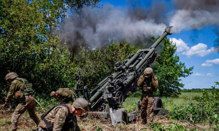 Ukrainian service members fire a shell from a M777 Howitzer near a frontline in Donetsk Region, on June 6, 2022. (Stringer/Reuters)