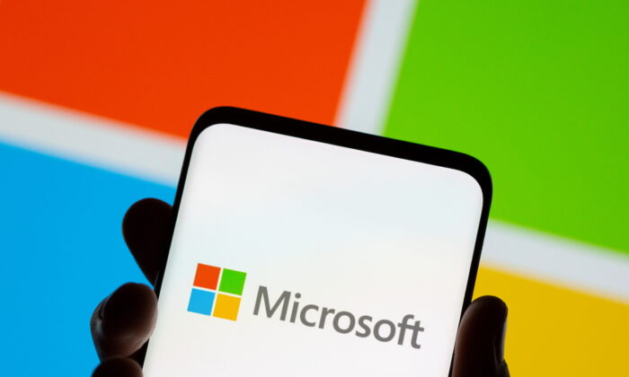 A phone is seen in front of a Microsoft logo displayed in this illustration taken on July 26, 2021. (Dado Ruvic/Reuters)