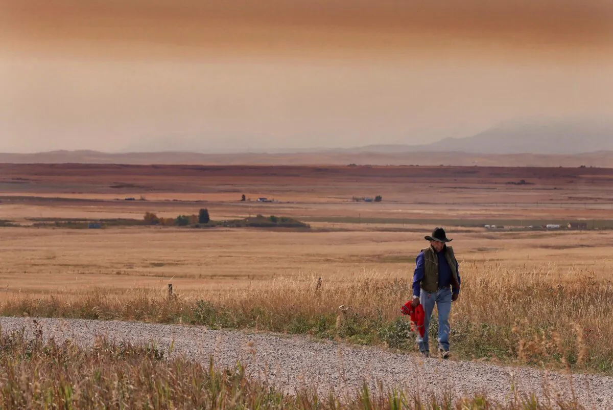 A resident of the Blood Reserve, southeast of Waterton Lakes National Park, Alta., walks down a side road near Standoff, Alberta, in a file photo. (The Canadian Press/David Rossiter)