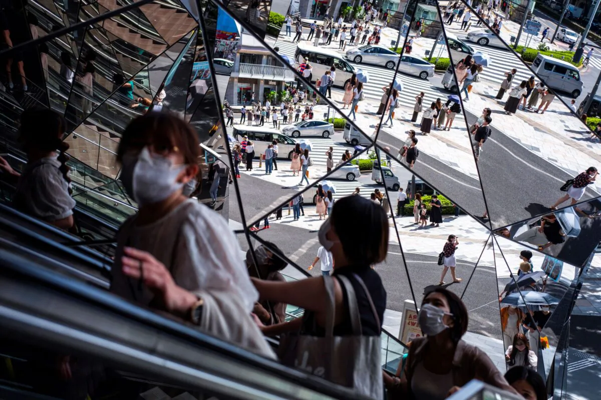 People wearing protective masks are reflected in the mirror at a shopping mall in Tokyo amid the coronavirus disease (COVID-19) outbreak on Aug. 19, 2021. (Athit Perawongmetha/Reuters)