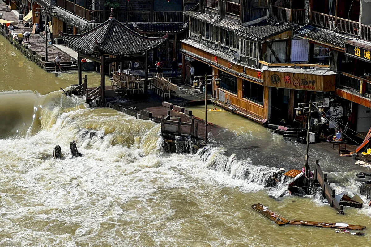 Flood waters sweep through the ancient town of Feng Huang in central China's Hunan Province, on June 4, 2022. (AP Photo)