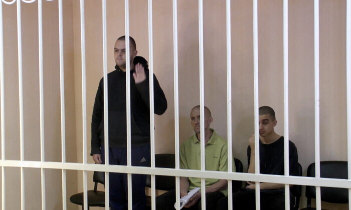 Britons Aiden Aslin (L), Shaun Pinner, and Moroccan Brahim (R) Saadoun in a courtroom cage at a location given as Donetsk, Ukraine, on June 7, 2022. (Supreme Court of Donetsk People's Republic/Handout via Reuters)