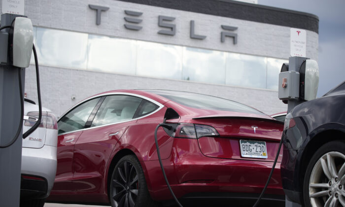 A 2021 Model 3 sedan is connected to a charger at a Tesla dealership in Littleton, Colo., on June 27, 2021. (David Zalubowski/AP Photo)