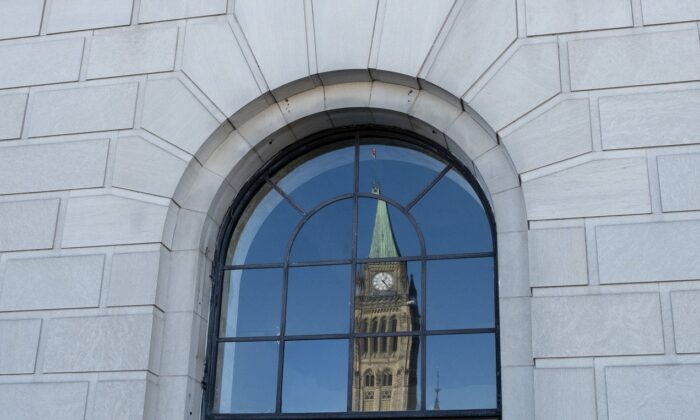 The Peace tower is reflected in a window in Ottawa, March 26, 2019. (The Canadian Press/Adrian Wyld)
