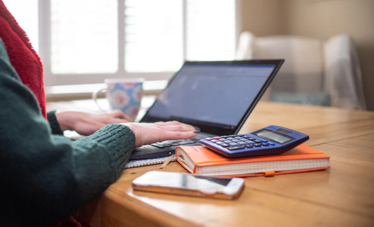 A woman using a laptop on a dining room table set up as a remote office to work from home on March 4, 2020. (Joe Giddens/PA Wire)
