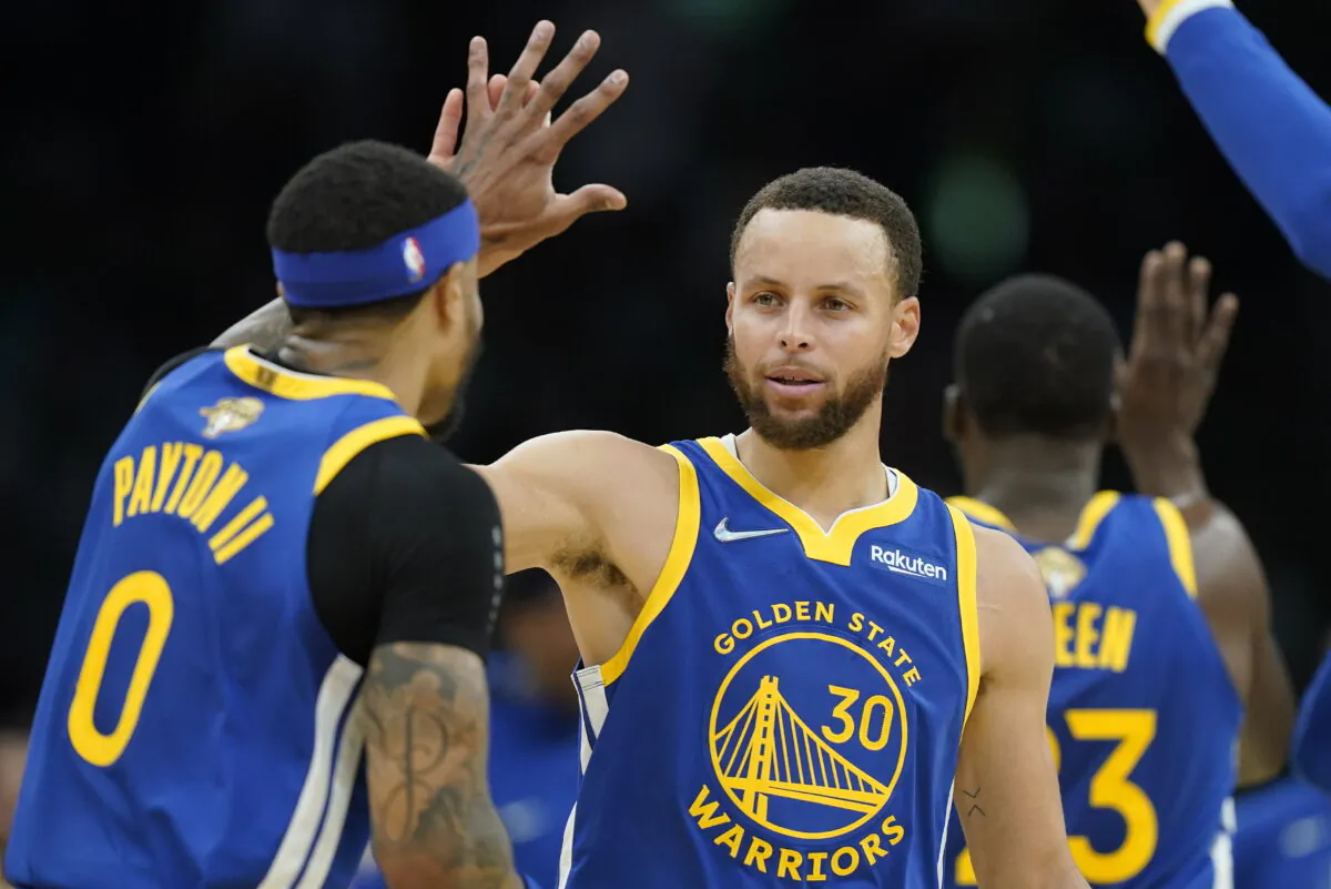 Golden State Warriors guard Stephen Curry (30) high fives Golden State Warriors guard Gary Payton II (0) during the second quarter of Game 6 of basketball's NBA Finals against the Boston Celtics in Boston on June 16, 2022. (Steven Senne/AP Photo)