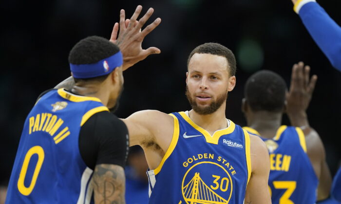 Golden State Warriors guard Stephen Curry (30) high fives Golden State Warriors guard Gary Payton II (0) during the second quarter of Game 6 of basketball's NBA Finals against the Boston Celtics in Boston on June 16, 2022. (Steven Senne/AP Photo)