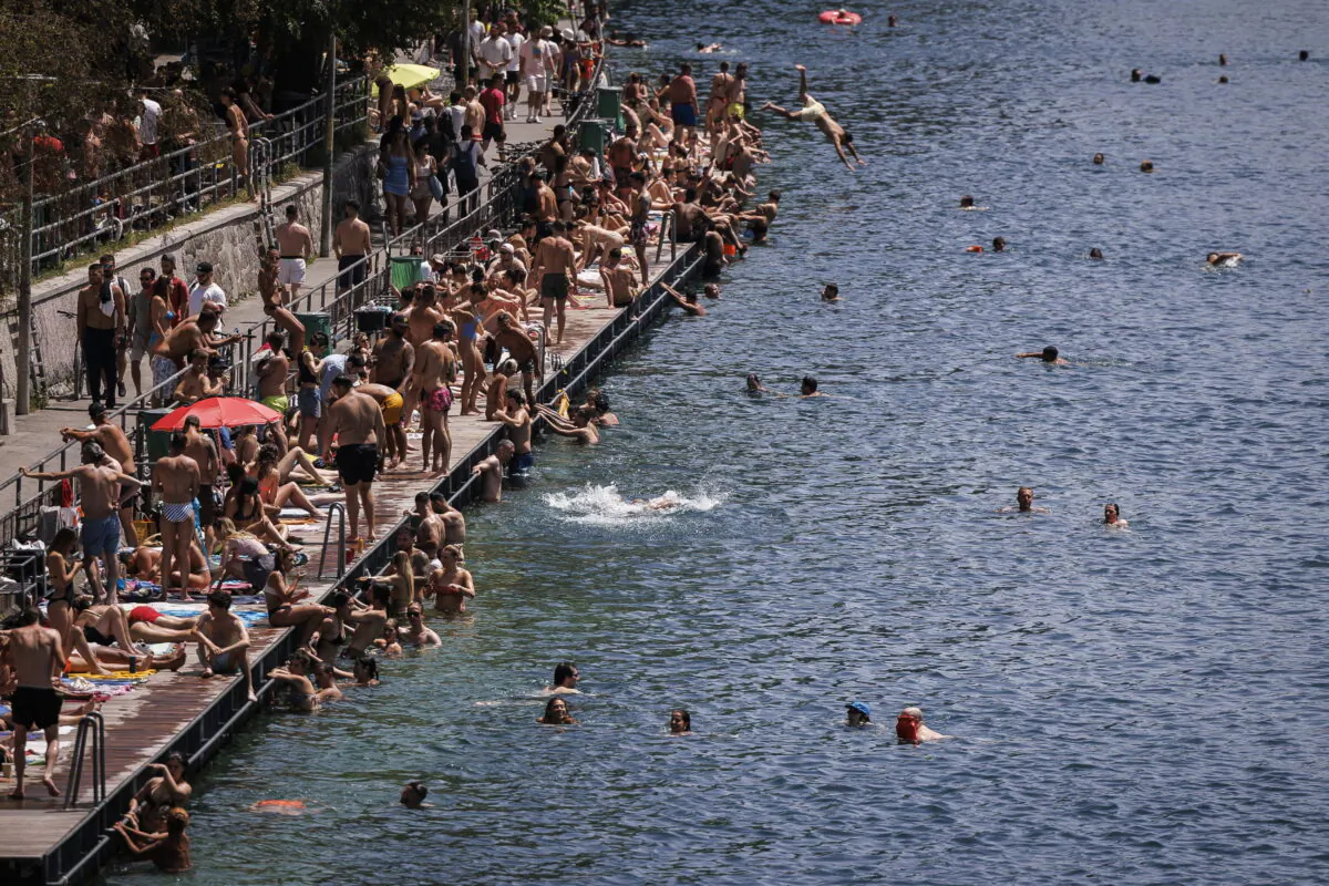 People swim in the river Limmat at Letten, in Zurich, Switzerland, on June 18, 2022. (Michael Buholzer/Keystone via AP)