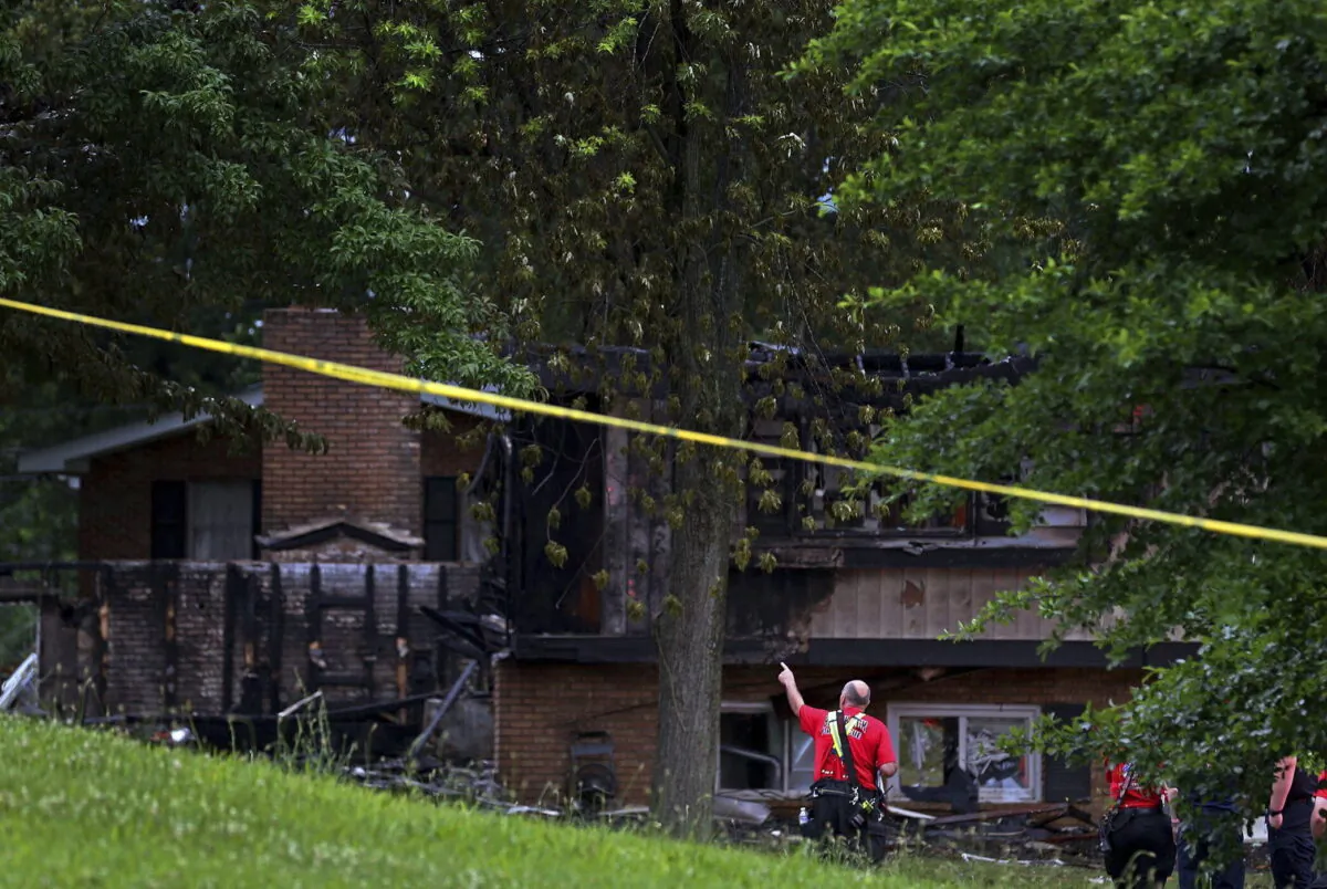 Fire officials look over the scene of a fatal house explosion in northern St. Louis County just west of Spanish Lake, Mo., on June 17, 2022. (Christian Gooden/St. Louis Post-Dispatch via AP)