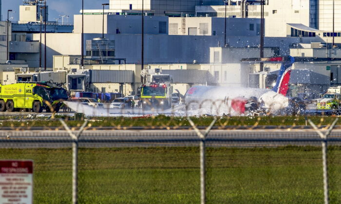 Firefighting units next to a Red Air plane that caught fire after the front landing gear collapsed upon landing after arriving from Santo Domingo, Dominican Republic to Miami International Airport in Miami on June 21, 2022. (Pedro Portal/Miami Herald via AP)