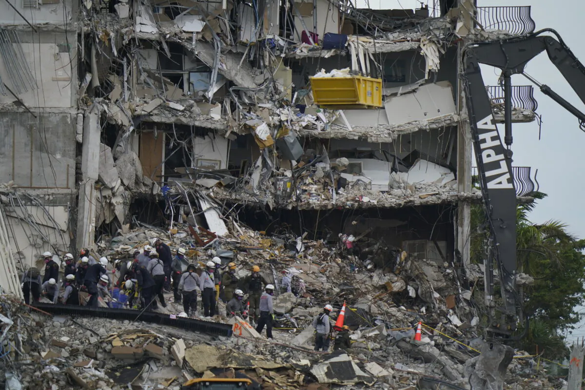 Search and rescue personnel work atop the rubble at the Champlain Towers South condo building, where scores of people remain missing after it partially collapsed the week before, in Surfside, Fla., on June 30, 2021. (Lynne Sladky/AP Photo)