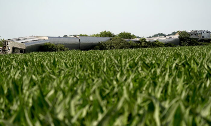An Amtrak train which derailed after striking a dump truck is seen beyond a corn field near Mendon, Mo., on June 27, 2022. (Charlie Riedel/AP Photo)