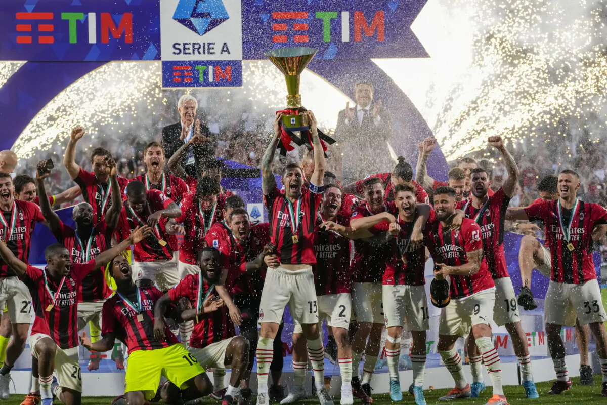 AC Milan's Alessio Romagnoli players holds up the trophy as he celebrates with teammates after winning the Italian Serie A title at the end of a match against Sassuolo, at the Citta del Tricolore stadium, in Reggio Emilia, Italy, on May 22, 2022. (Antonio Calanni/AP Photo)