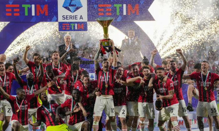 AC Milan's Alessio Romagnoli players holds up the trophy as he celebrates with teammates after winning the Italian Serie A title at the end of a match against Sassuolo, at the Citta del Tricolore stadium, in Reggio Emilia, Italy, on May 22, 2022. (Antonio Calanni/AP Photo)