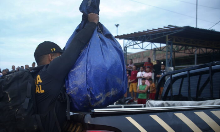 A Federal Police officer loads a truck with items found during a search for Indigenous expert Bruno Pereira and freelance British journalist Dom Phillips in Atalaia do Norte, Amazonas state, Brazil, on June 12, 2022. (Edmar Barros/AP Photo)