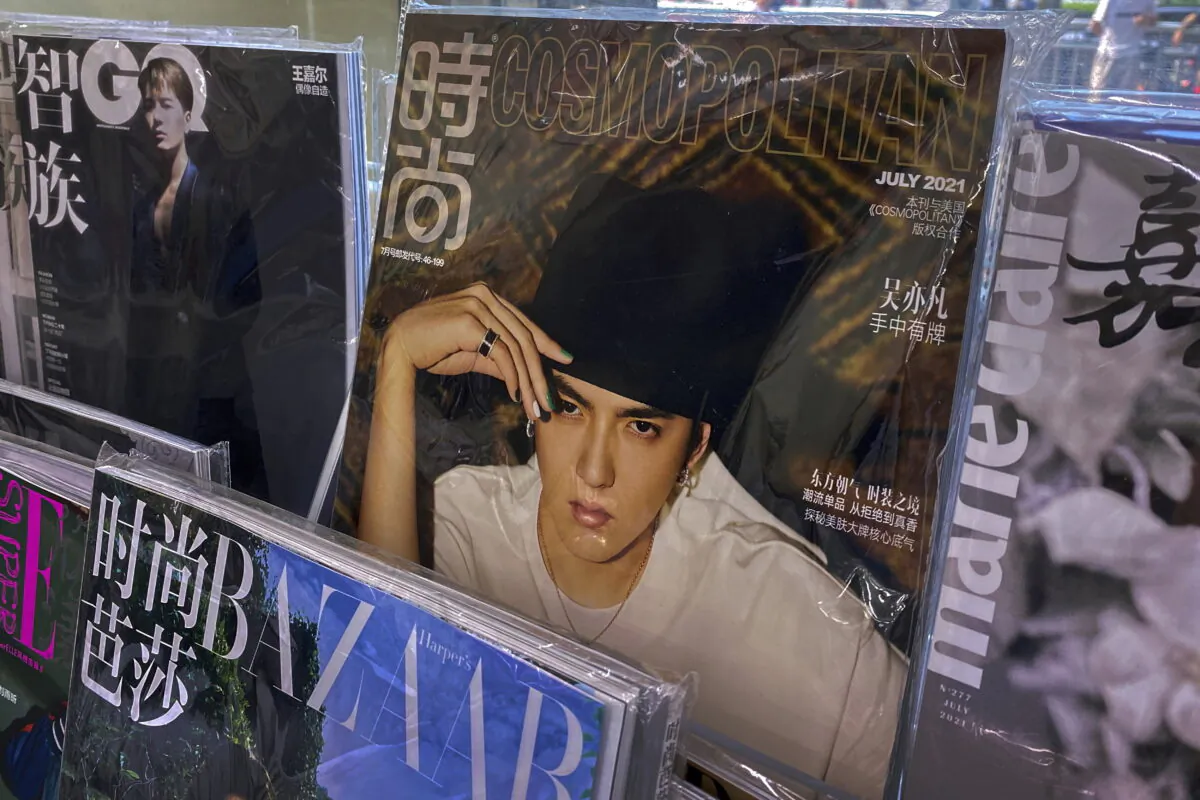 A fashion magazine showing Chinese-Canadian singer Kris Wu (C) on display for sale on a bookshelves at a convenience store in Beijing on July 20, 2021. (Andy Wong/AP Photo)