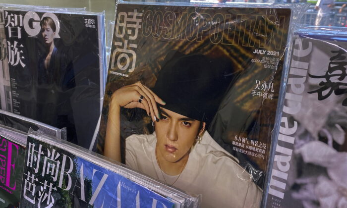 A fashion magazine showing Chinese-Canadian singer Kris Wu (C) on display for sale on a bookshelves at a convenience store in Beijing on July 20, 2021. (Andy Wong/AP Photo)