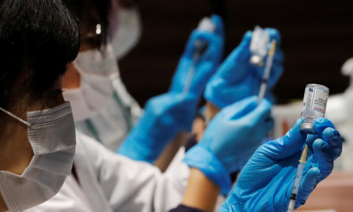 Health care workers prepare doses of a COVID-19 vaccine before administering them to staffers of Japan's supermarket group Aeon at the company's shopping mall in Chiba, Japan, on June 21, 2021. (Kim Kyung-Hoon/Reuters)
