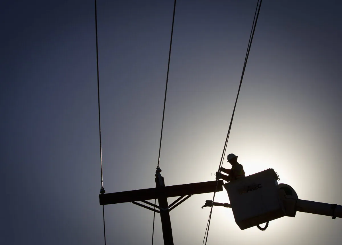 An electrical line technician works on restoring power after a tornado in Vilonia, Ark., on April 29, 2014. (Carlo Allegri/Reuters)