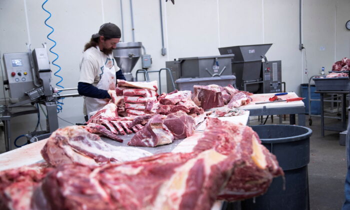 Employee cuts fresh beef meat into large pieces at a meat processing plant in Corydon, Ind., on Jan. 31, 2022. (Amira Karaoud/Reuters)