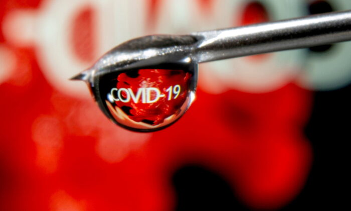 The word "COVID-19" is reflected in a drop on a syringe needle in this illustration taken on Nov. 9, 2020. (Dado Ruvic/Illustration/Reuters)
