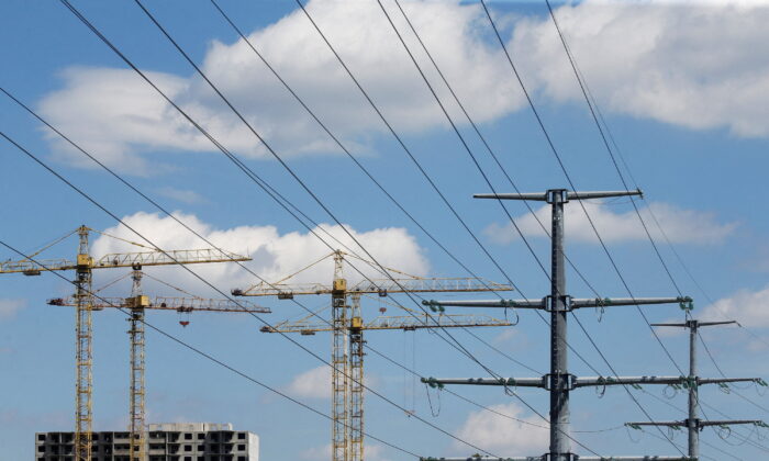 Building cranes and power lines connecting pylons of high-tension electricity next to a construction site of new apartment blocks in Kyiv, Ukraine on July 10, 2020.  (Valentyn Ogirenko/Reuters)