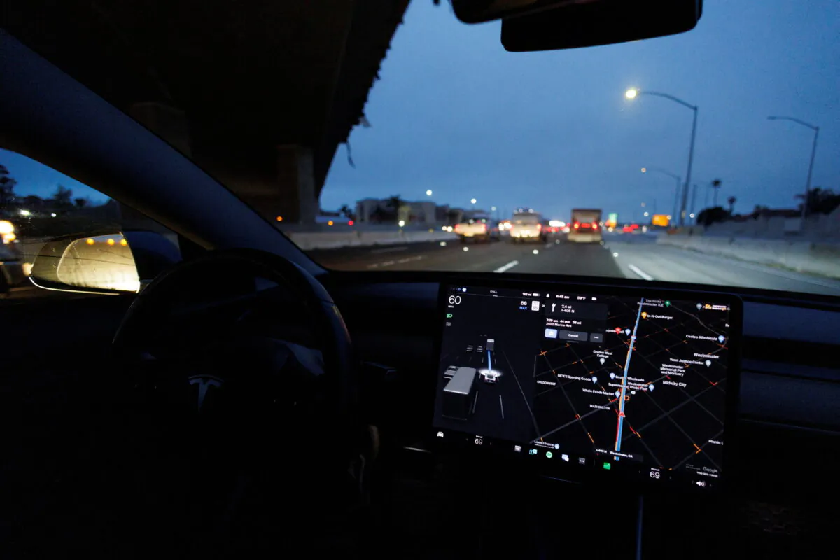 A Tesla Model 3 vehicle drives on autopilot along the 405 highway in Westminster, Calif., on March 16, 2022. (Mike Blake/Reuters)