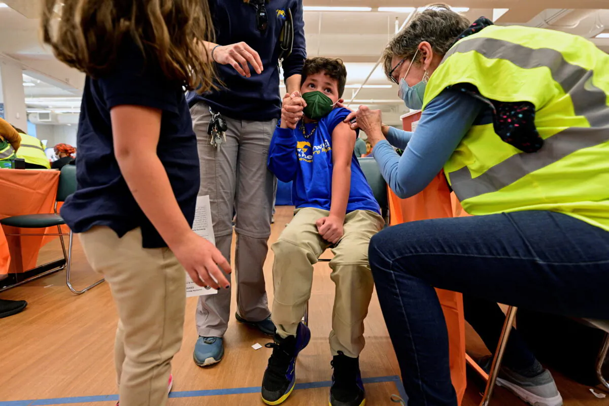 A child reacts while receiving a dose of the Pfizer-BioNTech coronavirus disease (COVID-19) vaccine at Smoketown Family Wellness Center in Louisville, Kentucky, U.S., Nov. 8, 2021. (Reuters/Jon Cherry/File Photo)