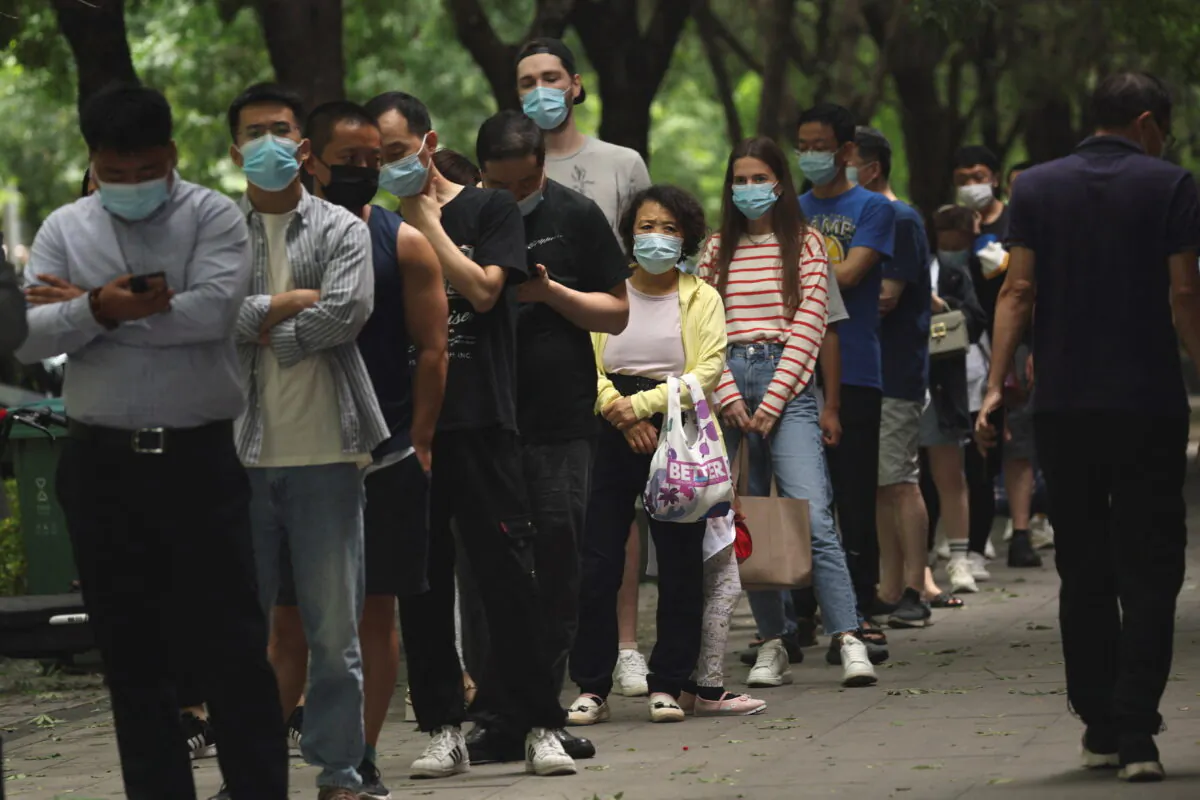People line up for nucleic acid tests at a mobile testing booth, following the COVID-19 outbreak, in Beijing, China, on June 13, 2022. (Tingshu Wang/Reuters)