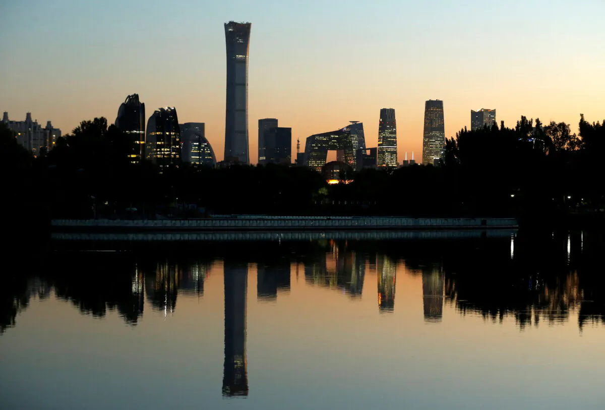 The cityscape of the Beijing Central Business District, or Beijing CBD, is reflected in a pond during sunset, on Oct. 17, 2018.  (Thomas Peter/Reuters)