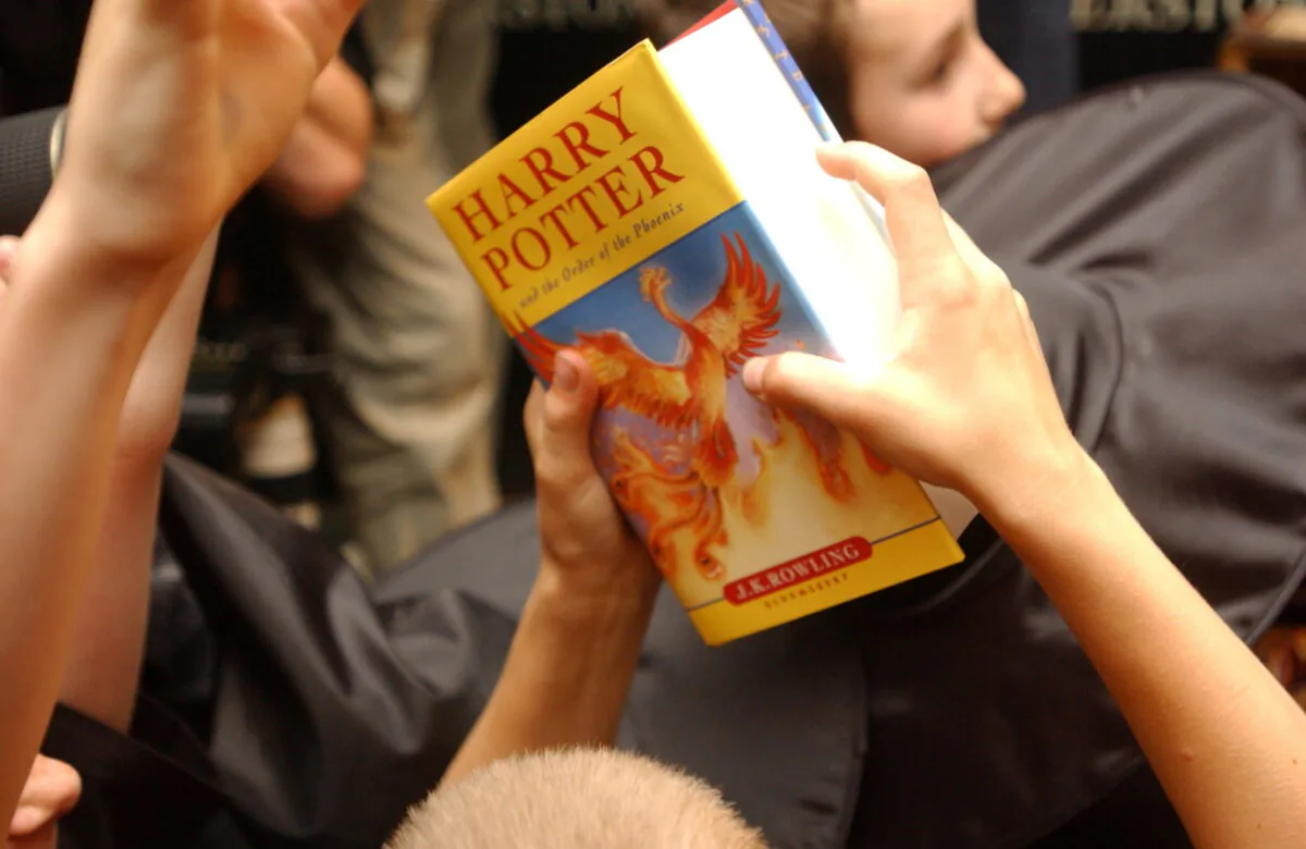 A child holds a copy of "Harry Potter and the Order of the Phoenix," at Waterstone's bookshop in central London on June 21, 2003. (Sinead Lynch/Reuters)