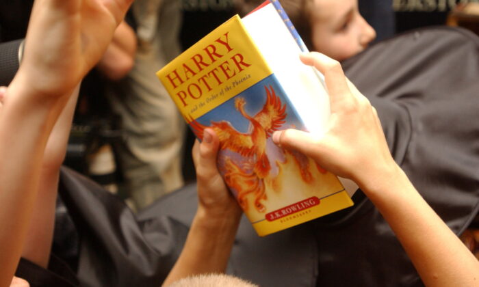 A child holds a copy of "Harry Potter and the Order of the Phoenix," at Waterstone's bookshop in central London on June 21, 2003. (Sinead Lynch/Reuters)