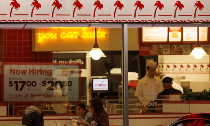 A "Now hiring" sign on the window of an IN-N-OUT fast food restaurant in Encinitas, Calif., on May 9, 2022. (Mike Blake/Reuters)