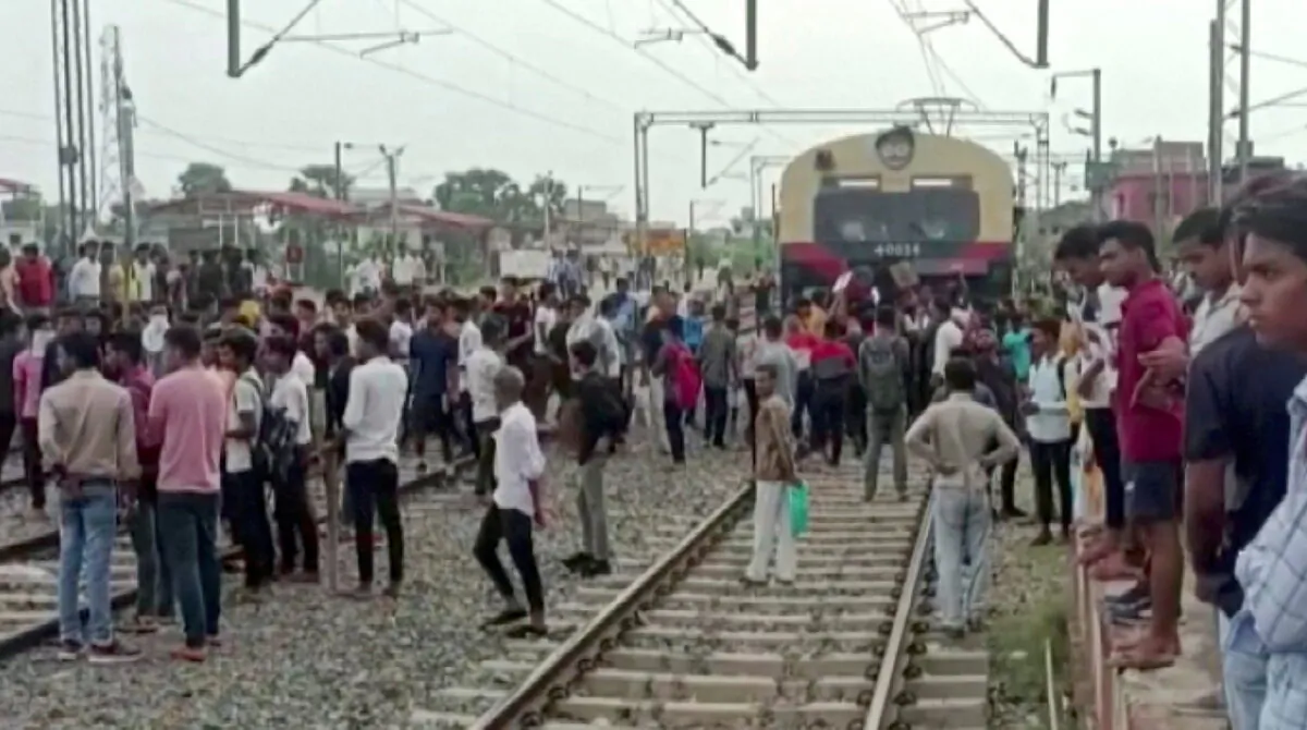 Demonstrators block a train as they protest against "Agnipath scheme" for recruiting personnel for armed forces in Jehanabad, Bihar, India, on June 16, 2022, in a still image obtained from a handout video. (Ani/Handout via Reuters)