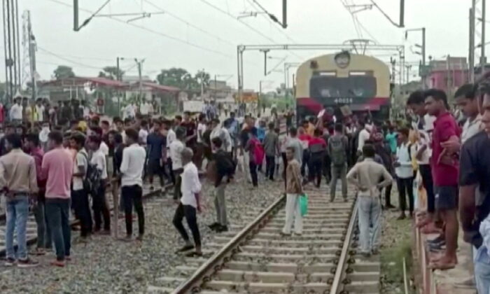 Demonstrators block a train as they protest against "Agnipath scheme" for recruiting personnel for armed forces in Jehanabad, Bihar, India, on June 16, 2022, in a still image obtained from a handout video. (Ani/Handout via Reuters)