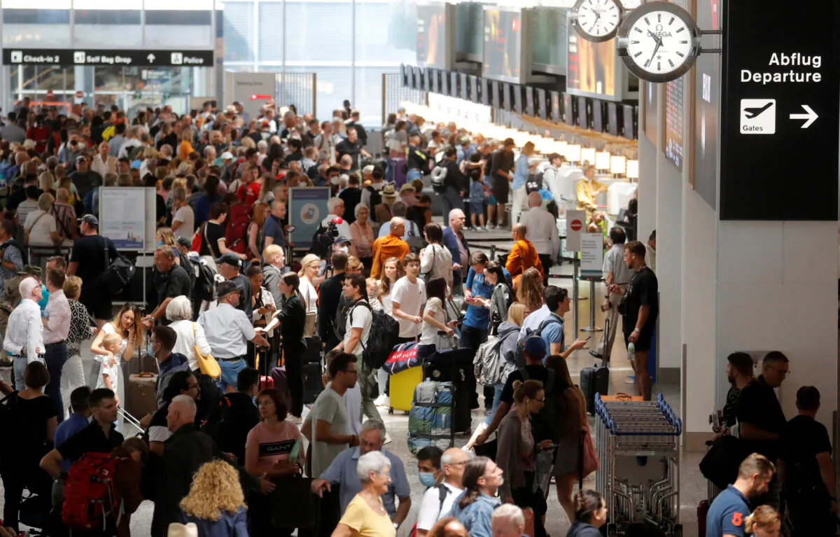 Passengers wait in front of check-in counters in a terminal at Zurich Airport in Switzerland on June 15, 2022. (Arnd Wiegmann/Reuters)