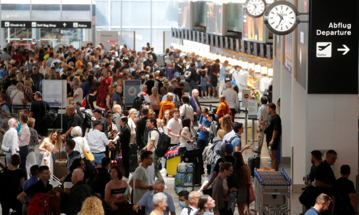 Passengers wait in front of check-in counters in a terminal at Zurich Airport in Switzerland on June 15, 2022. (Arnd Wiegmann/Reuters)