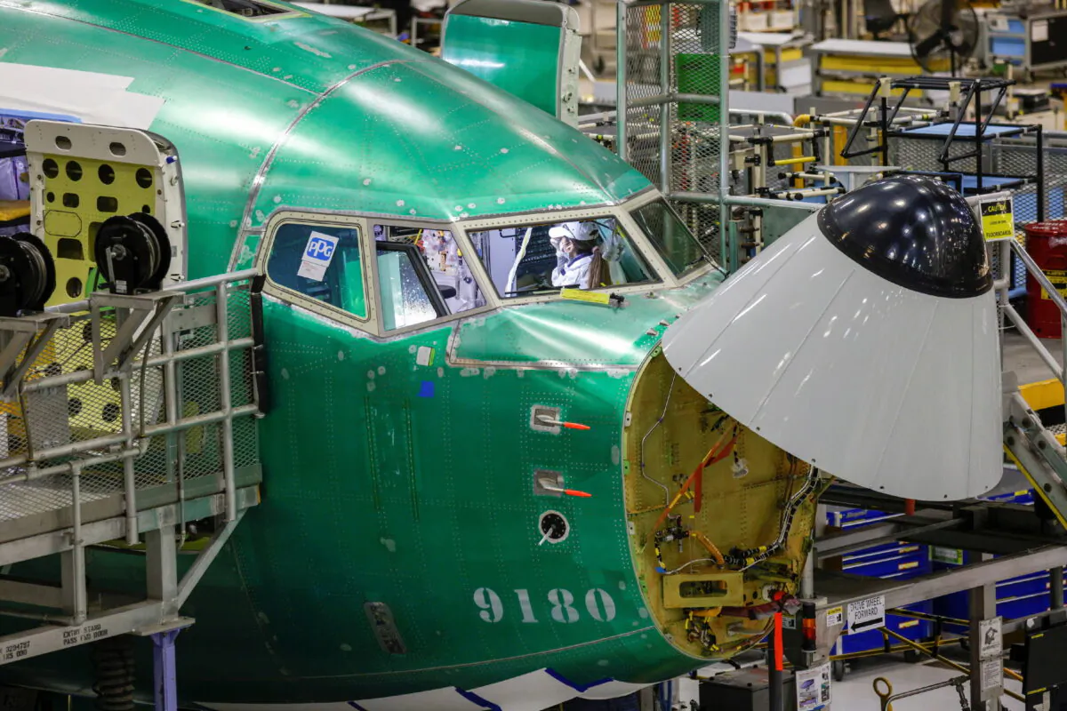 An employee works in the cockpit of a Boeing P-8 Poseidon maritime patrol aircraft on the production line at Boeing's 737 factory in Renton, Wash., on Nov. 18, 2021. (Jason Redmond/Reuters)