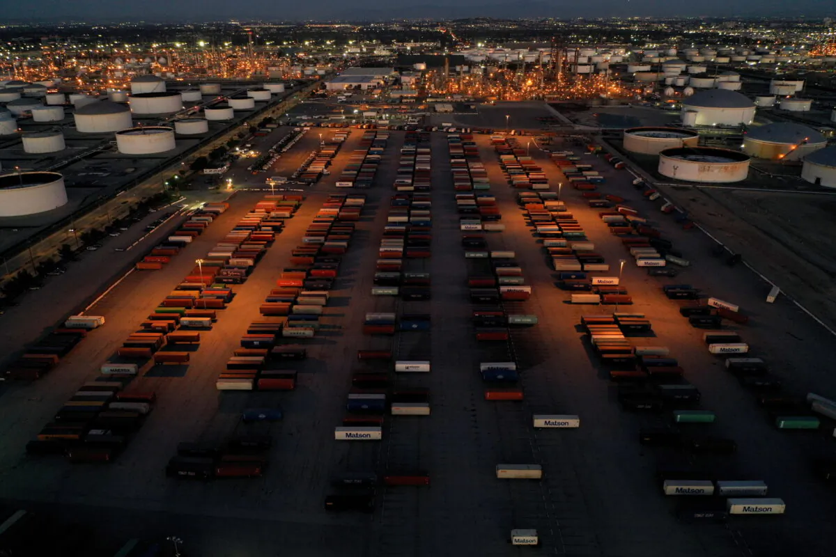 Cargo shipping containers are seen (by a drone) in a storage yard surrounded by petroleum storage tanks and oil refineries in Carson, Calif., on Mar. 11, 2022. (Reuters/Bing Guan)