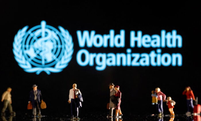 Small figurines are seen in front of displayed World Health Organization logo in this illustration taken Feb. 11, 2022. (Dado Ruvic/Reuters)