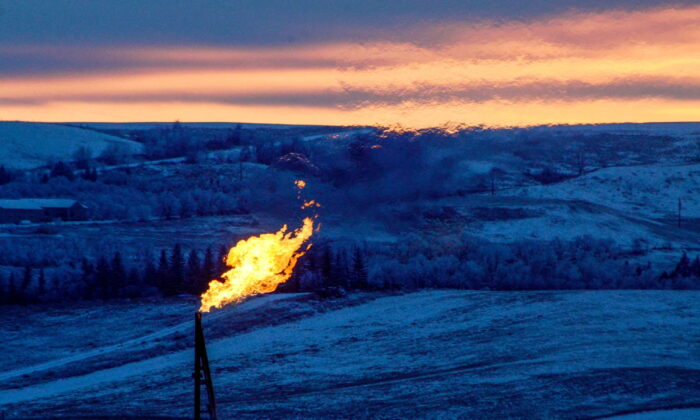 A natural gas flare on an oil well pad burns as the sun sets outside Watford City, N.D., on Jan. 21, 2016. (Andrew Cullen/Reuters)