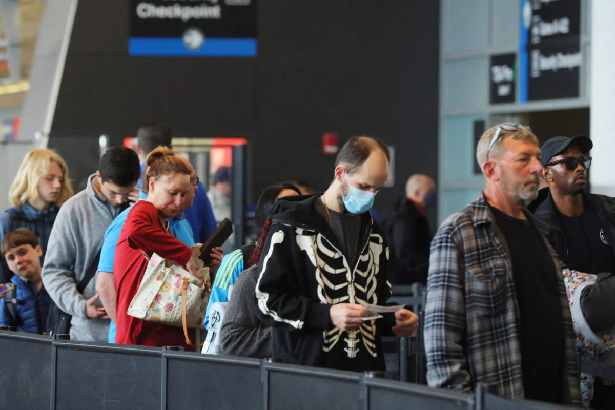 Travelers wait in line at a security checkpoint at Logan International Airport in Boston, Mass., on April 19, 2022. (Brian Snyder/Reuters)
